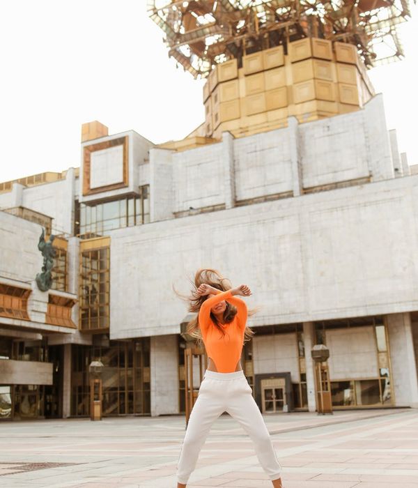 Woman feeling energetic and vibrant in a bright space.